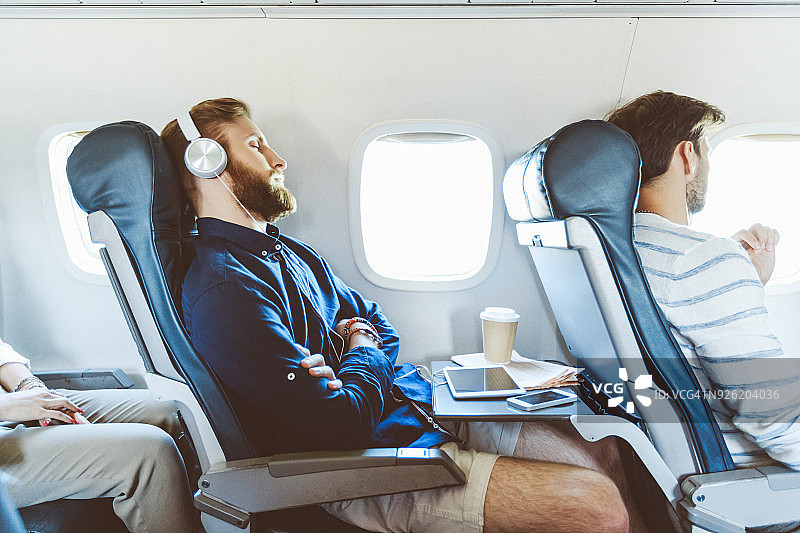 飞行途中使用平板电脑的男乘客图片素材