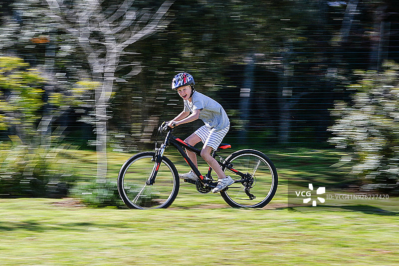 微笑看着镜头的骑山地自行车的男孩图片素材