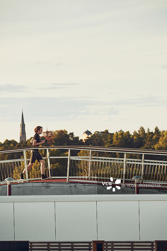 在人行天桥上慢跑的女人图片素材