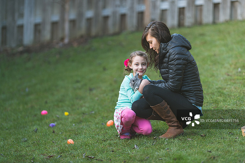 在后院和母亲一起抱着小兔子图片素材