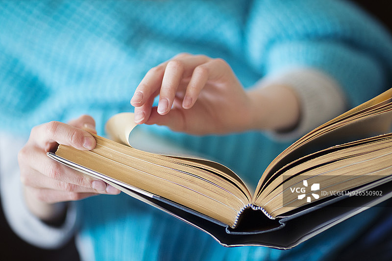 特写：儿童翻看精装书图片素材