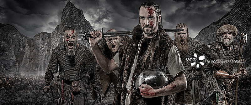 维京战士持武器列队，前方是维京宝藏和山脉图片素材