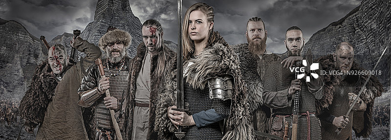 维京战士持武器列队，前方是维京宝藏和山脉图片素材