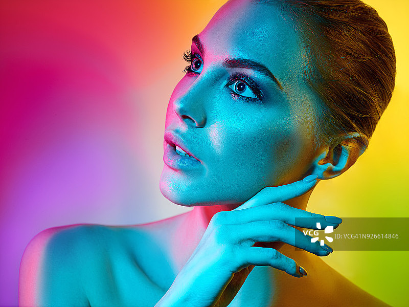 在演播室中以彩色灯光摆姿势的高级时装模特图片素材