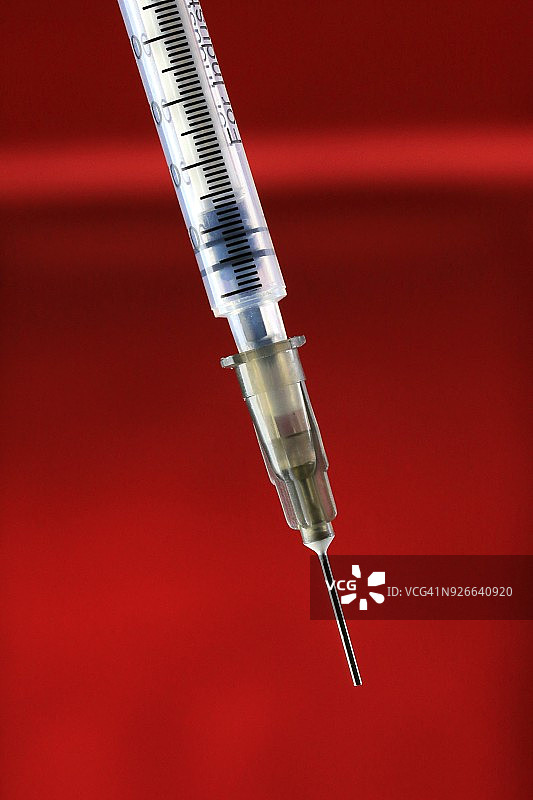 红色背景上的皮下注射针头和注射器图片素材