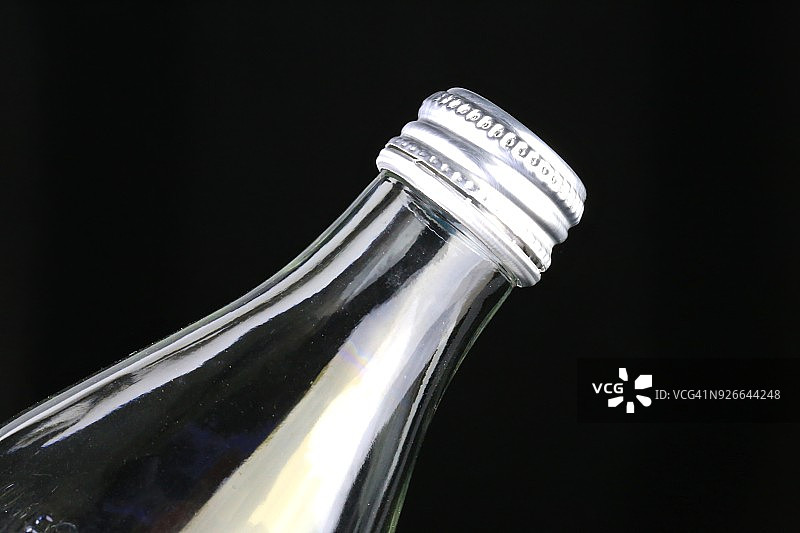 黑色背景上的透明苏打水瓶图片素材