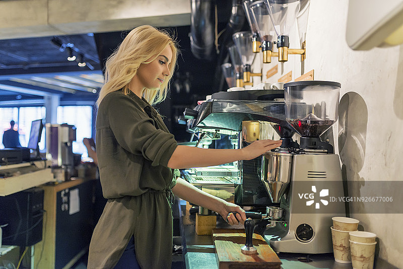 咖啡师在咖啡店使用意式浓缩咖啡机图片素材