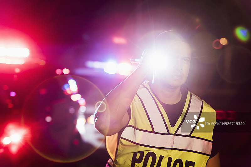 西班牙裔警察在夜晚，闪烁着灯光图片素材