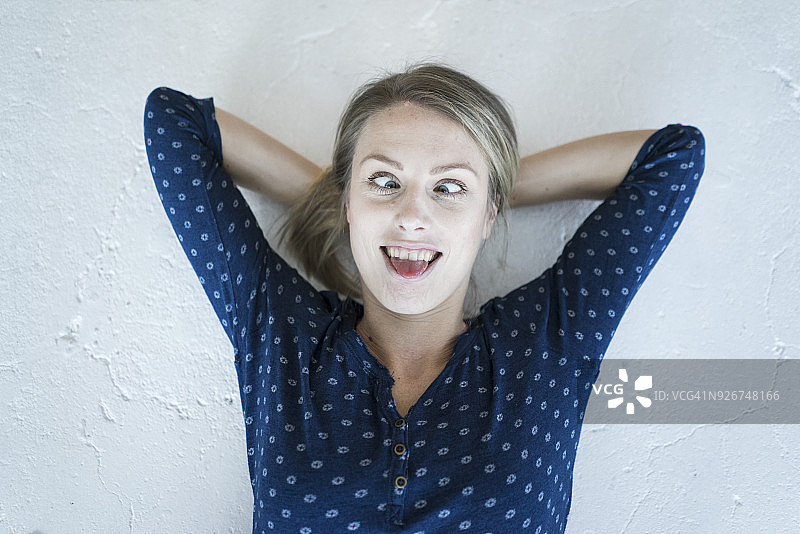 躺在地板上做鬼脸的年轻女子肖像图片素材