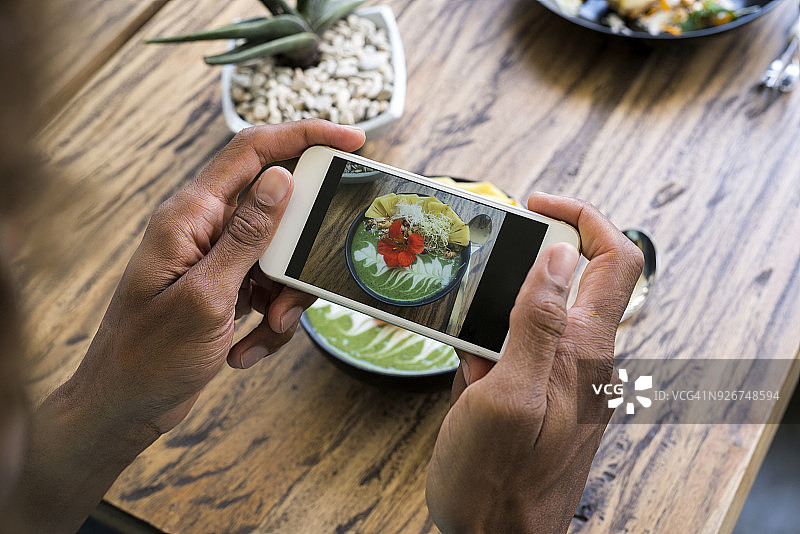 男人用智能手机拍摄冰沙碗图片素材