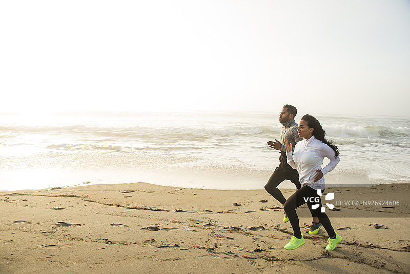 在海滩上慢跑的男人和女人图片素材