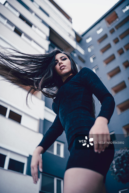在城市街道上旋转秀发的女性图片素材