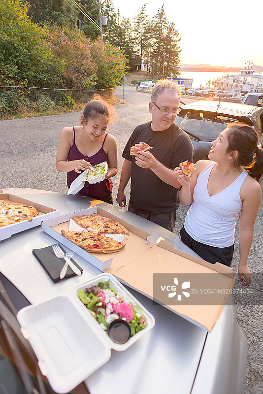 父女吃披萨和沙拉，等待渡轮图片素材