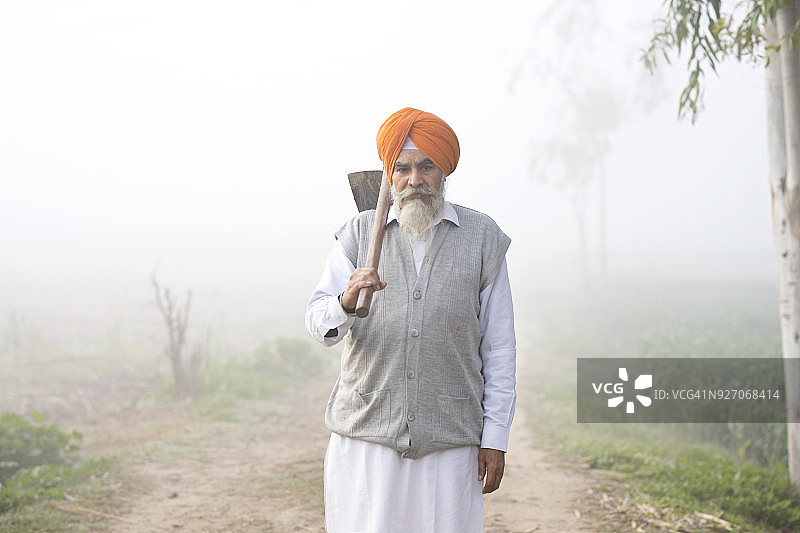 印度农民拿着锄头图片素材