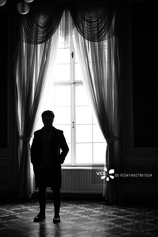 年轻男人站在老博物馆里图片素材