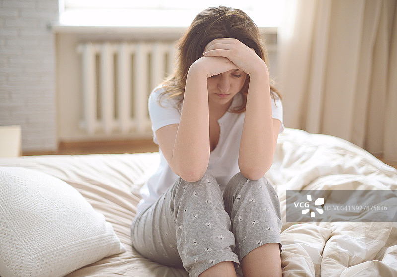 卧室里不高兴的年轻女性图片素材