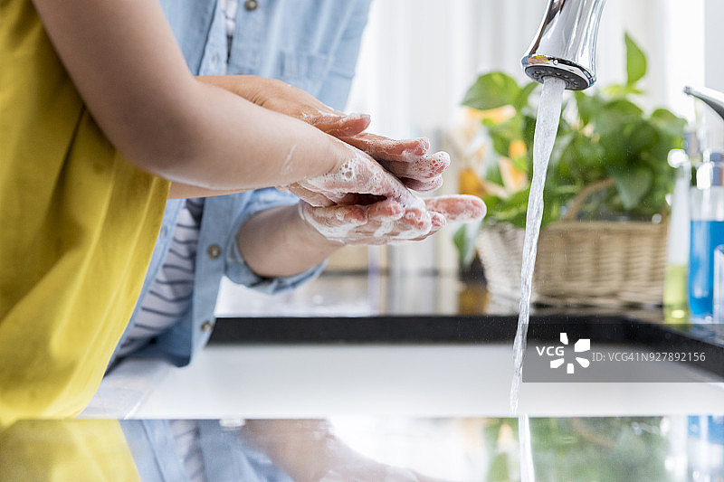 母亲帮助孩子洗手图片素材