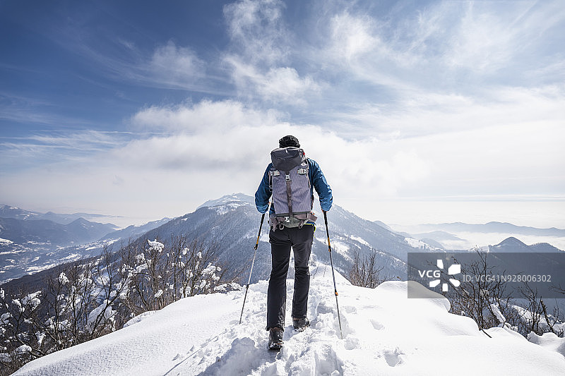 徒步者在雪山顶峰行走图片素材