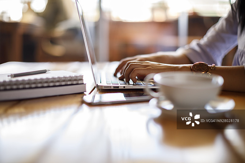 在咖啡馆用笔记本电脑工作的女人图片素材