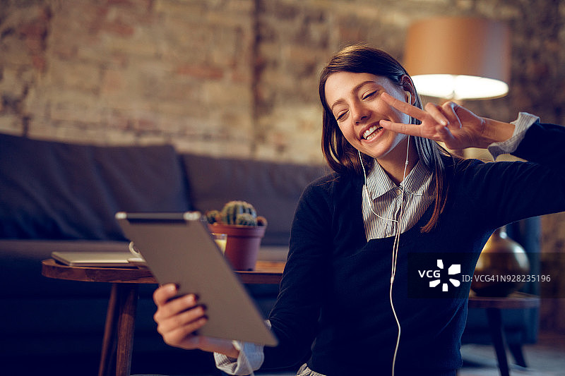 年轻女人在室内用平板电脑进行视频聊天图片素材