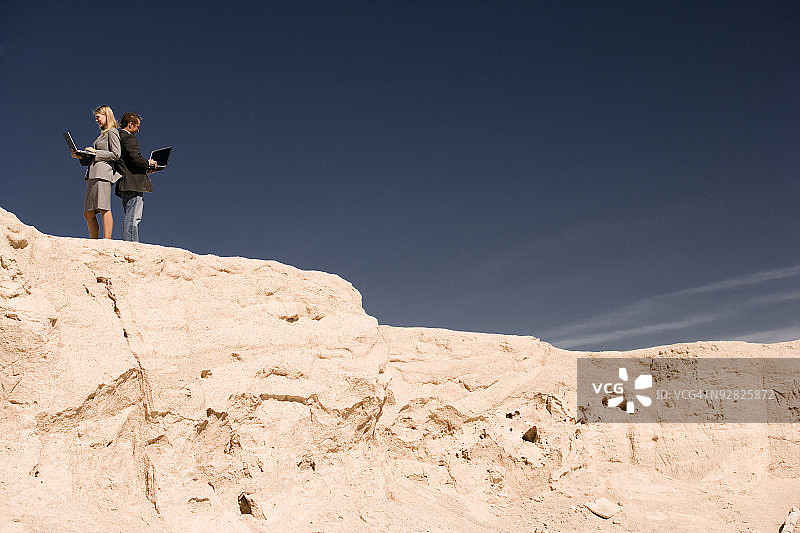 商人在岩层上使用电脑图片素材
