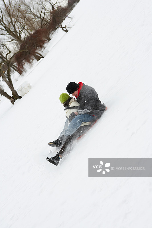 情侣在雪地里滑雪橇图片素材