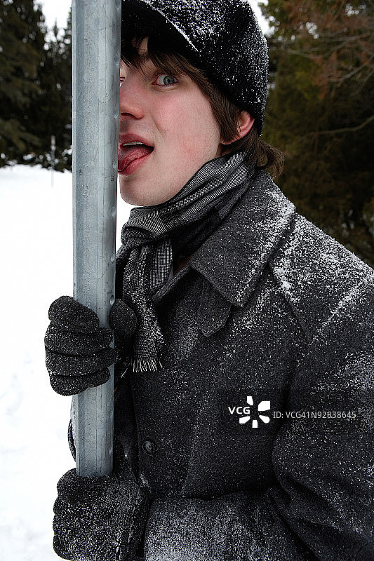 男人的舌头粘在室外冰冻的柱子上图片素材