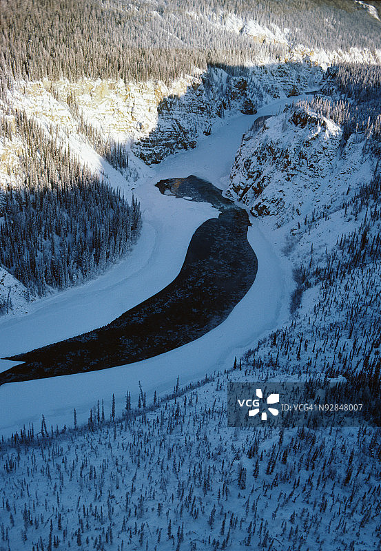加拿大纳汉尼国家公园穿山而过的冰冻河流图片素材