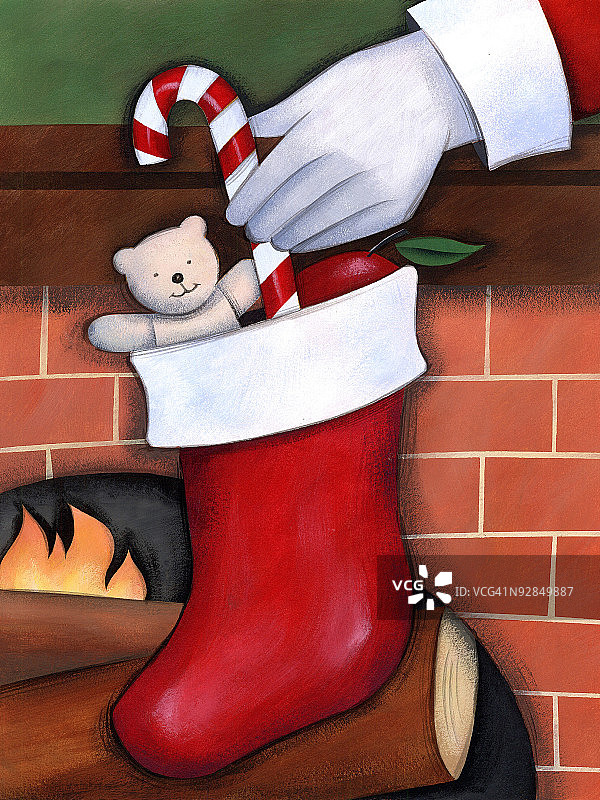 圣诞老人手部将拐杖糖放入袜子图片素材