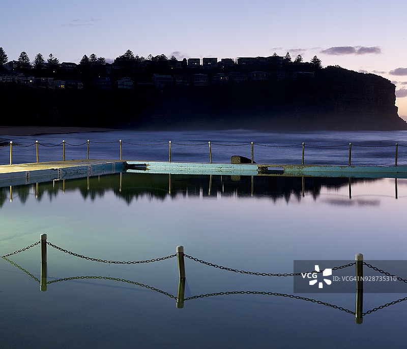 比尔戈拉新南威尔士州平静的海水倒映着带链条围栏的海水池图片素材
