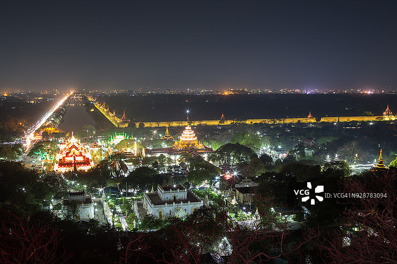 夜晚的曼德勒山：皎多枝宝塔、建筑群及曼德勒皇宫护城河全景图片素材
