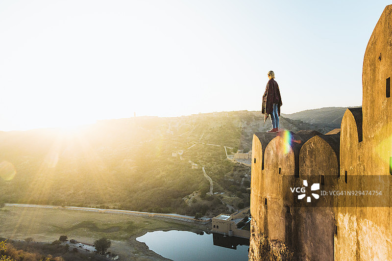 清晨，年轻女人走在斋浦尔的琥珀堡的墙上图片素材