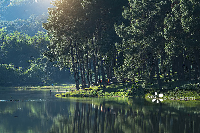 快乐的亚洲时尚男子在自然背景下背包，在假日概念旅行中放松身心，复古色调和柔焦图片素材