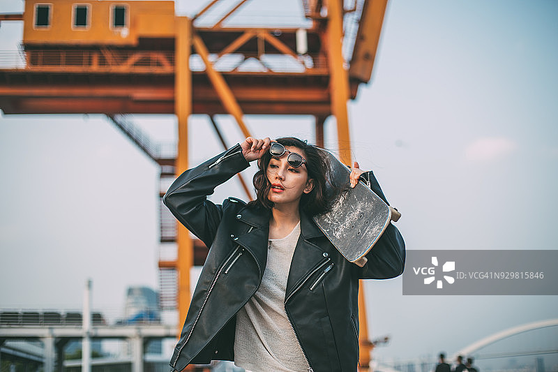 肩扛滑板的年轻女人图片素材