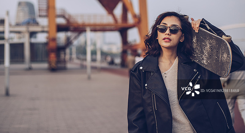 时髦女人肩上扛着滑板图片素材