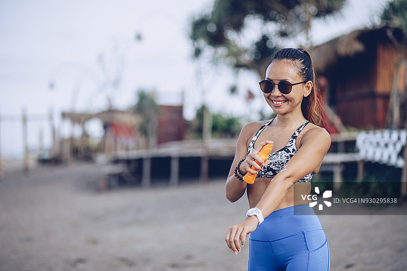 运动员在海滩使用防晒霜图片素材