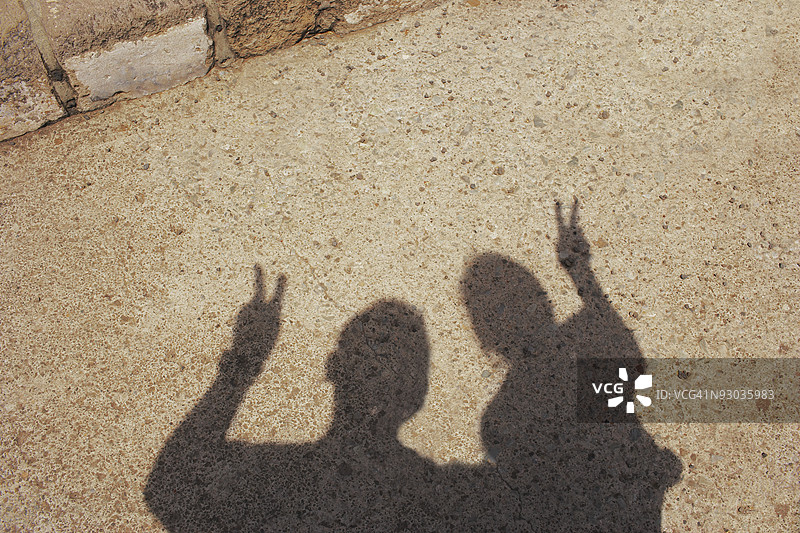 两个做出和平手势的人影图片素材