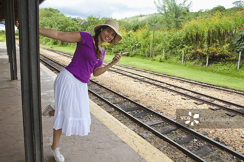 在巴西米纳斯吉拉斯州的提拉登特斯，女人站在铁路站台上图片素材
