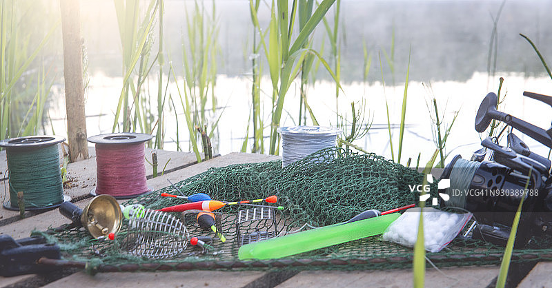 河岸上的钓鱼诱饵，背景是冉冉升起的太阳图片素材