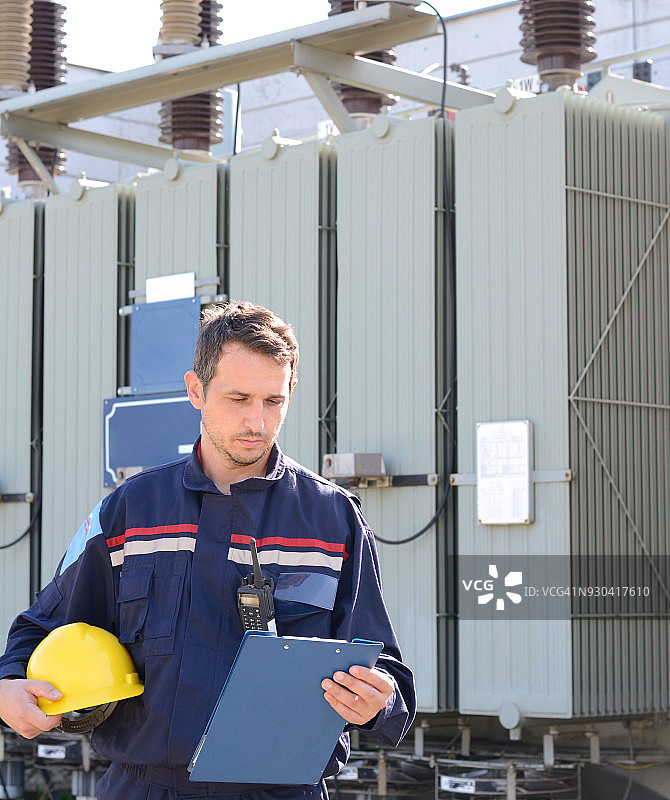 电气工程师在高压变压器附近的发电站工作图片素材