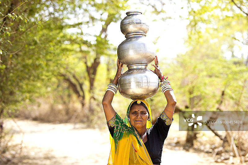 头顶水罐的印度妇女图片素材
