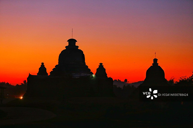 缅甸若开邦妙乌佛塔的紫色、橙色、黄色、红色日落剪影图片素材