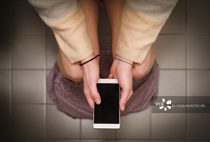 在卫生间使用智能手机图片素材