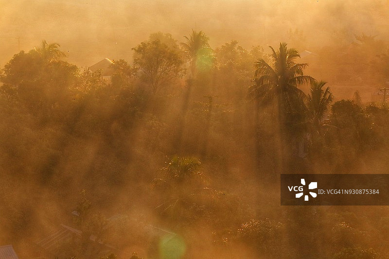 缅甸若开邦妙乌森林的戏剧性日落：蓝、橙、黄、红色天空剪影图片素材