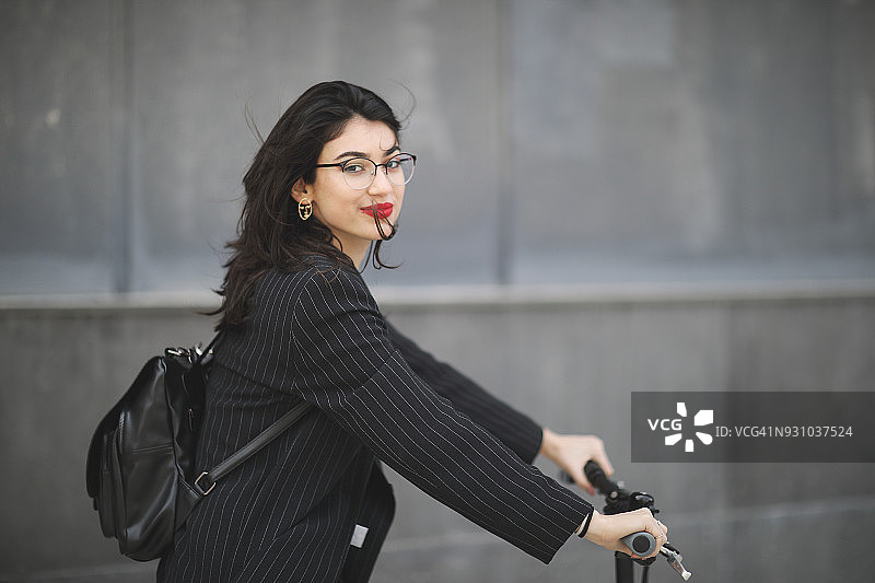 在城市中骑自行车兜风的女商人图片素材