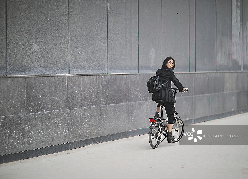 在城市中骑自行车兜风的女商人图片素材