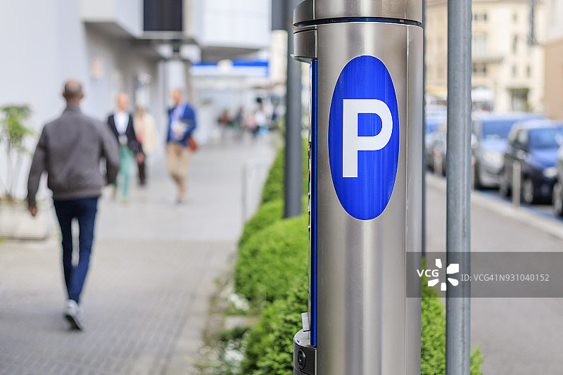 不锈钢停车计时器和人行道上熙熙攘攘的人群图片素材