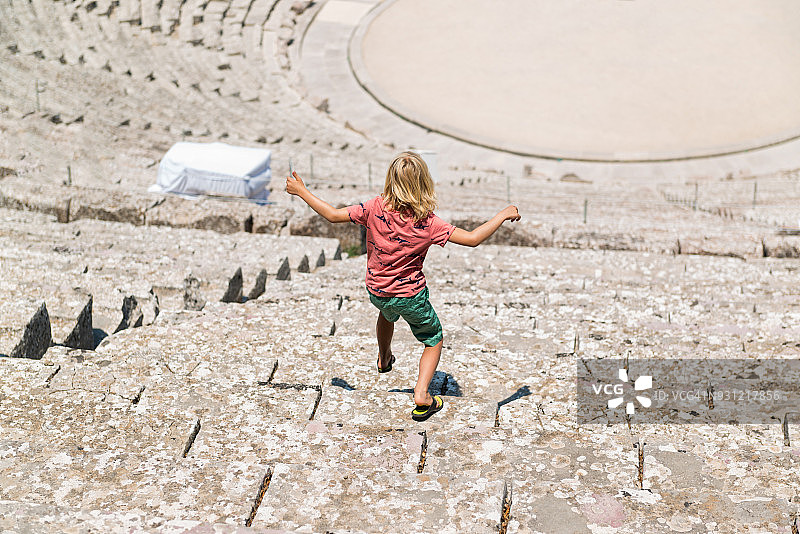 在希腊埃皮达鲁斯古剧院的男孩图片素材