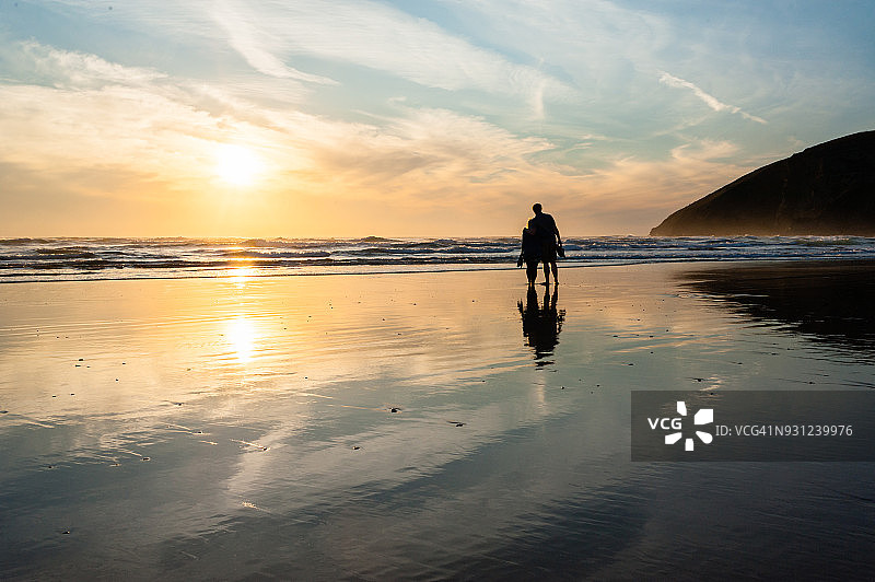 日落时分海滩上情侣的轮廓图片素材