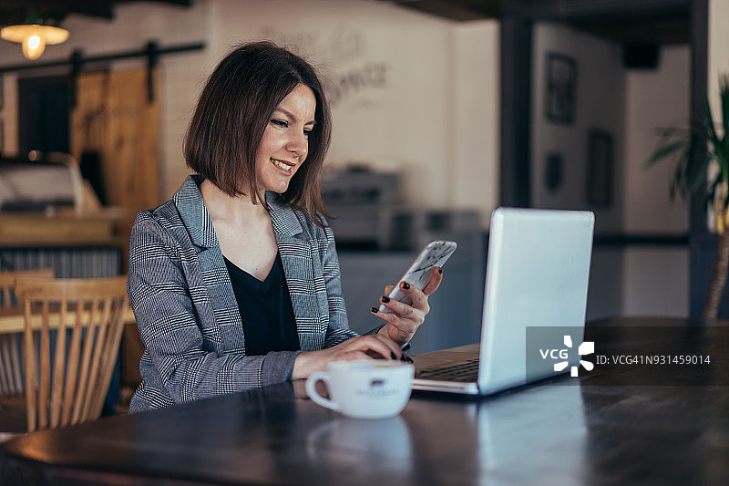 在咖啡馆用信用卡进行在线支付的女人图片素材